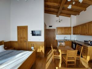 een slaapkamer met een bed en een keuken met houten kasten bij Airy Studio Pirin Golf Aparthotel & Spa H2A92 in Razlog