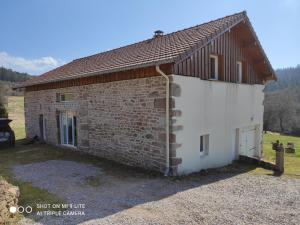 mały ceglany budynek z brązowym dachem w obiekcie Gîte chez Mimile nature et déconnexion w mieście Tendon