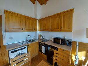 una cucina con armadi in legno, lavandino e piano cottura di Airy Studio Pirin Golf Aparthotel & Spa H2A92 a Razlog