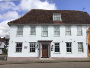 een wit huis met een bruin dak bij The Great House Lavenham Hotel & Restaurant in Lavenham