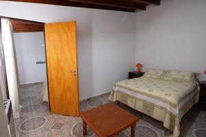 a bedroom with a bed and a wooden door at Departamento Casimiro-Nuevo Amplio en Zona Centro in El Calafate