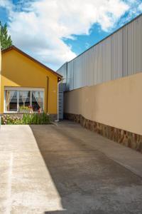 a yellow building with a sidewalk next to it at Departamento Casimiro-Nuevo Amplio en Zona Centro in El Calafate