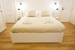 a white bed with two towels on top of it at Residenza Sforza Apartment 1 in Naples