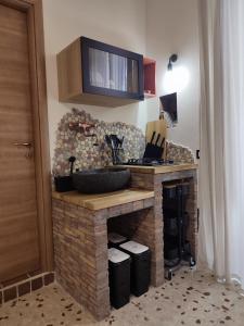 uma cozinha com um balcão de pedra e um lavatório em L'OLIVA CONTESA - alloggio turistico - la ROSSA em Gaeta