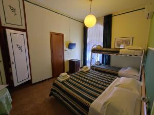a bedroom with a bed and a desk at Hotel Le Grazie in Portovenere