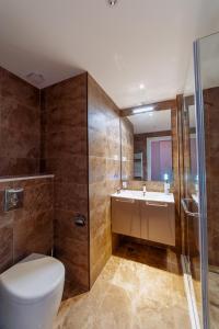 um banheiro com vaso sanitário, pia e chuveiro em Onyx Palace DeLux em Batumi