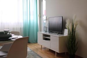 a living room with a tv on a dresser at Arena Zagreb Premium Apartment in Zagreb