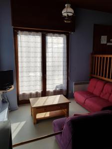 a living room with a red couch and a coffee table at Chalet Le Sambuis in Saint-Colomban-des-Villards