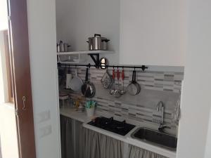 cocina con fregadero y encimera con utensilios en Apartment Marifra Garden, en Taormina