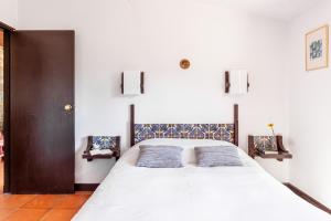 a bedroom with a large white bed with two pillows at Gerês Mountain Lake Views in Geres