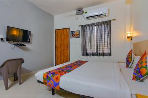 een slaapkamer met een bed en een televisie. bij FabExpress Crystal Stay in Bhubaneshwar