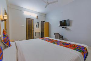 a bedroom with a white bed and a tv at FabExpress Crystal Stay in Bhubaneshwar
