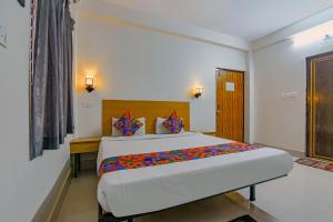 een slaapkamer met een groot bed in een kamer bij FabExpress Crystal Stay in Bhubaneshwar