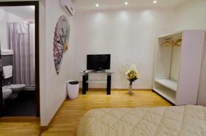 a room with a bed and a television and a bathroom at Via Palazzo Sanremo in Sanremo