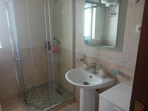 a bathroom with a shower and a sink and a mirror at Apartmán Dagmar in Durrës