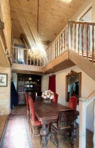 a dining room with a wooden table and a staircase at La Maison bleue in Varzy