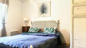 a bedroom with a bed with a blue comforter at La Maison bleue in Varzy