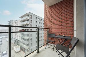 un balcone con 2 sedie e un tavolo su un edificio di Lux Apartment Browary Wrocławskie by Renters a Breslavia
