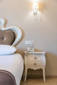 a bedroom with a bed and a nightstand with a lamp at Grand Hotel Park in Dubrovnik