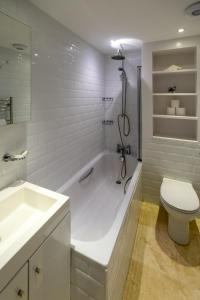 uma casa de banho com uma banheira, um WC e um lavatório. em York House em Aldeburgh