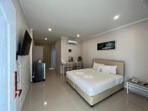 ein Hotelzimmer mit einem Bett und einem TV in der Unterkunft Siri Ville Hotel in Si Sa Ket