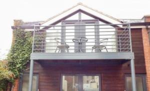 a balcony on a house with two chairs on it at The Apartment at St Georges Terrace in Cheltenham