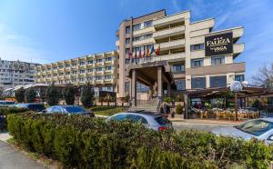 un hôtel avec des voitures garées dans un parking dans l'établissement Faleza Hotel by Vega, à Galaţi