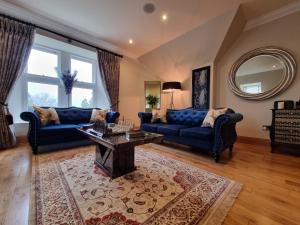 uma sala de estar com sofás azuis e uma mesa em DOLLARBEG CASTLE - The Tower - Luxury Apartment em Dollar