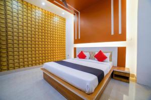 a bedroom with a large bed with red pillows at Hotel Anand International in New Delhi