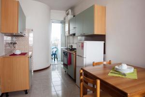 a kitchen with a table and a white refrigerator at Residence Danubio in San Benedetto del Tronto