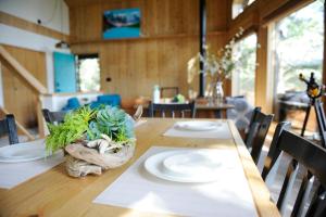 a wooden table with plates and a plant on it at Mid Century Modern Mountain Cabin in Invermere