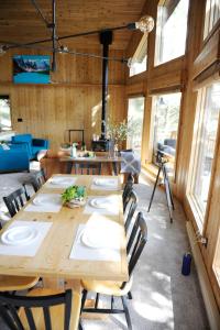 una sala da pranzo con tavoli e sedie in legno e finestre di Mid Century Modern Mountain Cabin a Invermere