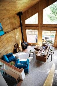 Mid Century Modern Mountain Cabin في إنفيرمير: غرفة معيشة مع أرائك زرقاء ومدفأة
