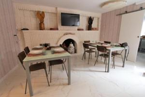 a dining room with tables and chairs and a fireplace at Casa Rural Mañanas Felices in Martos