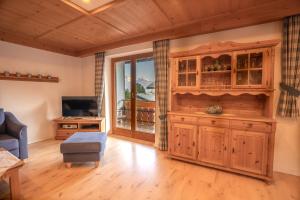 sala de estar con un gran armario de madera y TV en Alpenliebe Ferienwohnung, en Ofterschwang