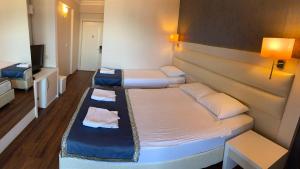 een kleine kamer met 2 bedden en een televisie bij GOLDKAYA HOTEL in Marmaris