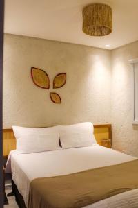 ein Schlafzimmer mit einem Bett und zwei Schmetterlingen an der Wand in der Unterkunft Casa Riacho in São Miguel dos Milagres