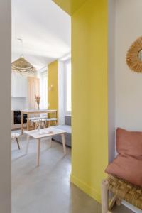 a living room with yellow walls and a table at Charmant T3 à proximité du Vieux-Port in Marseille