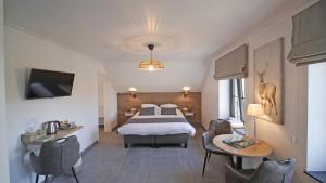 Habitación de hotel con cama, mesa y sillas en Auberge la Hutte Lurette, en Paliseul