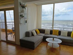 a living room with a couch and a view of the ocean at Apartmán Dagmar in Durrës