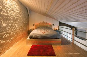 Bett in einem Zimmer mit Ziegelwand in der Unterkunft L’échappée Vendéenne in Saint-Aubin-la-Plaine