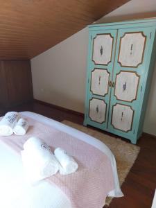 a bed with two white pillows and a blue cabinet at A Casinha da Vila in Vila Viçosa