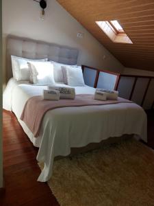 a bedroom with a large bed with two pillows on it at A Casinha da Vila in Vila Viçosa