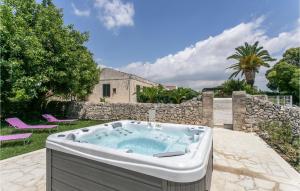 una bañera de hidromasaje en un patio con una pared de piedra en Casale Granati, en Rosolini