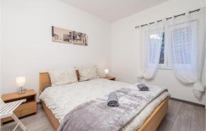 a bedroom with a bed and a chair and two windows at Nice Apartment In Cres With Wifi in Cres
