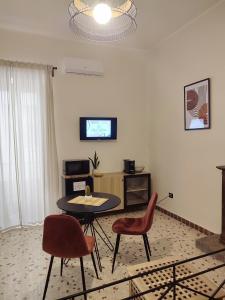 uma sala de estar com uma mesa e duas cadeiras em L'OLIVA CONTESA - alloggio turistico - la ROSSA em Gaeta