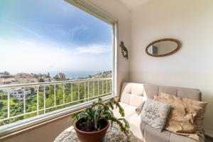 Sea view Carmel Mountain University في حيفا: غرفة معيشة مع أريكة ونافذة كبيرة