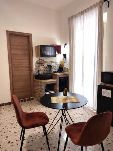ein Wohnzimmer mit einem Tisch und 2 Stühlen in der Unterkunft L'OLIVA CONTESA - alloggio turistico - la ROSSA in Gaeta