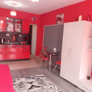 ポモリエにあるStudio Neraの赤いキャビネットとテーブル付きのキッチンが備わります。