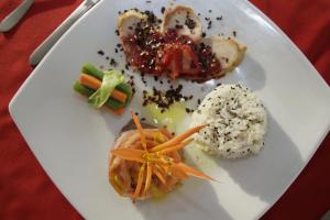 un plato de comida con arroz y verduras. en Hotel Los Puentes Comfacundi, en Girardot